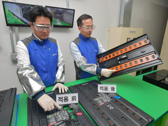 허은기 삼성SDI 중대형System개발팀장 전무(오른쪽)가 ESS용 특수 소화시스템의 효과를 설명하고 있다. 특수 소화시스템이 적용된 ESS 모듈커버에 불을 붙이자 불이 수초 내 꺼져 모듈 커버에 화재 손상이 없었지만(사진 오른쪽) 특수 소화시스템이 적용되지 않은 ESS 모듈커버는 불에 녹아 구멍이 날 정도로 손상을 입었다. <삼성SDI 제공>